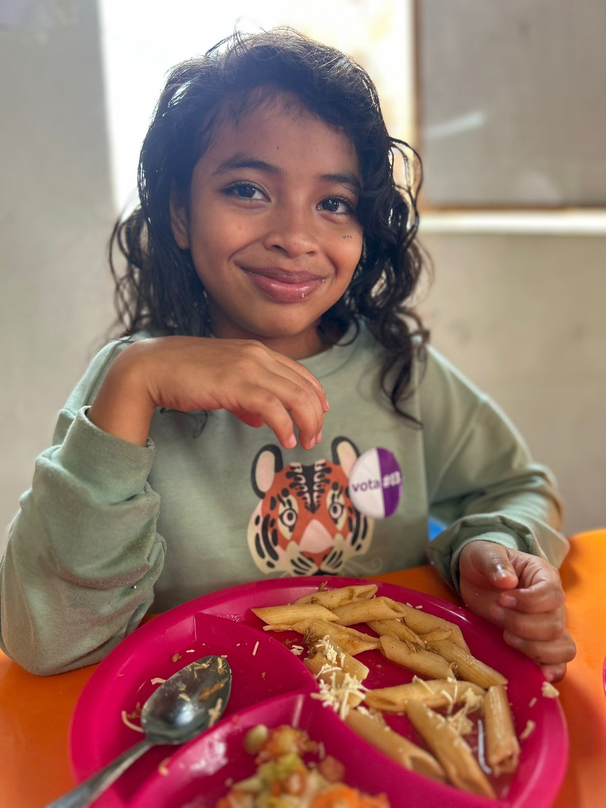 Niña sonriendo con su almuerzo en Fundación Betania