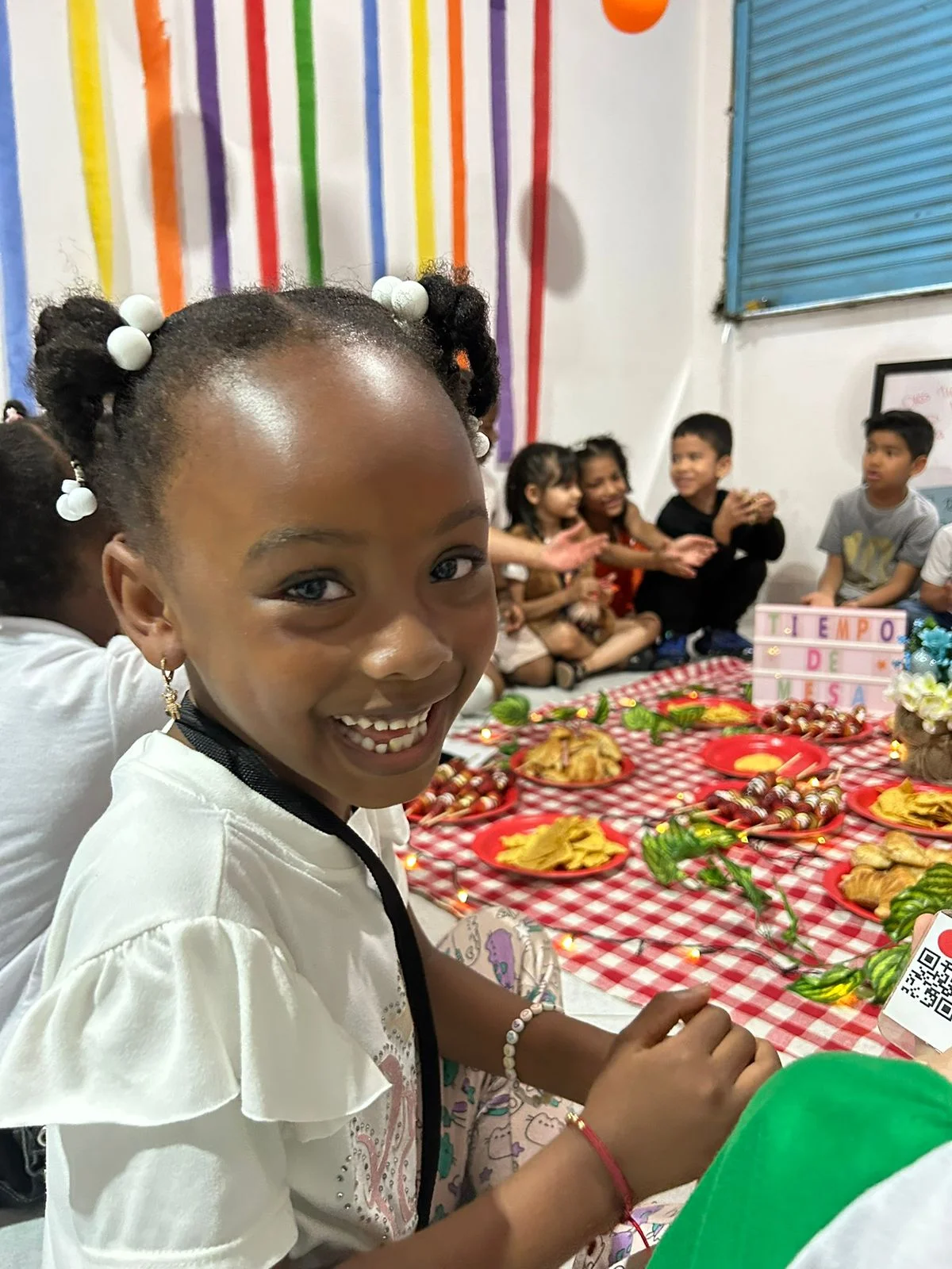 Niña sonriendo mientras come en el comedor comunitario de Betania